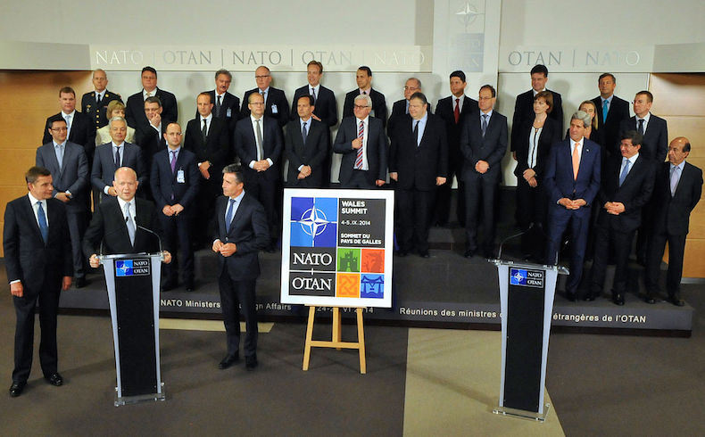 Secretario de Relaciones Exteriores británico, William Hague, saluda el logotipo de la Cumbre de la OTAN de 2014 en Gales, en septiembre de 2014.
